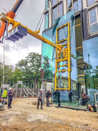 Installation of a large pane using a vacuum suction system and counterweights.