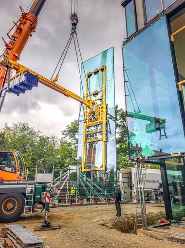 Installation of a large pane using a vacuum suction system and counterweights.