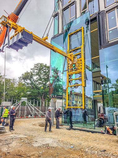 Lifting a large-format pane using a vacuum lifting system and counterweights.