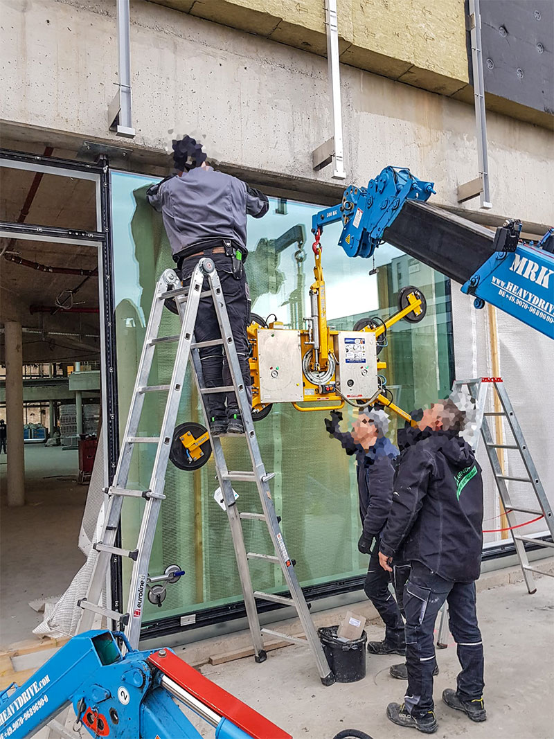 Glass installation at the Porsche Design Tower with Heavydrive MRK 168 mini crane and VSG 450 K suction system.