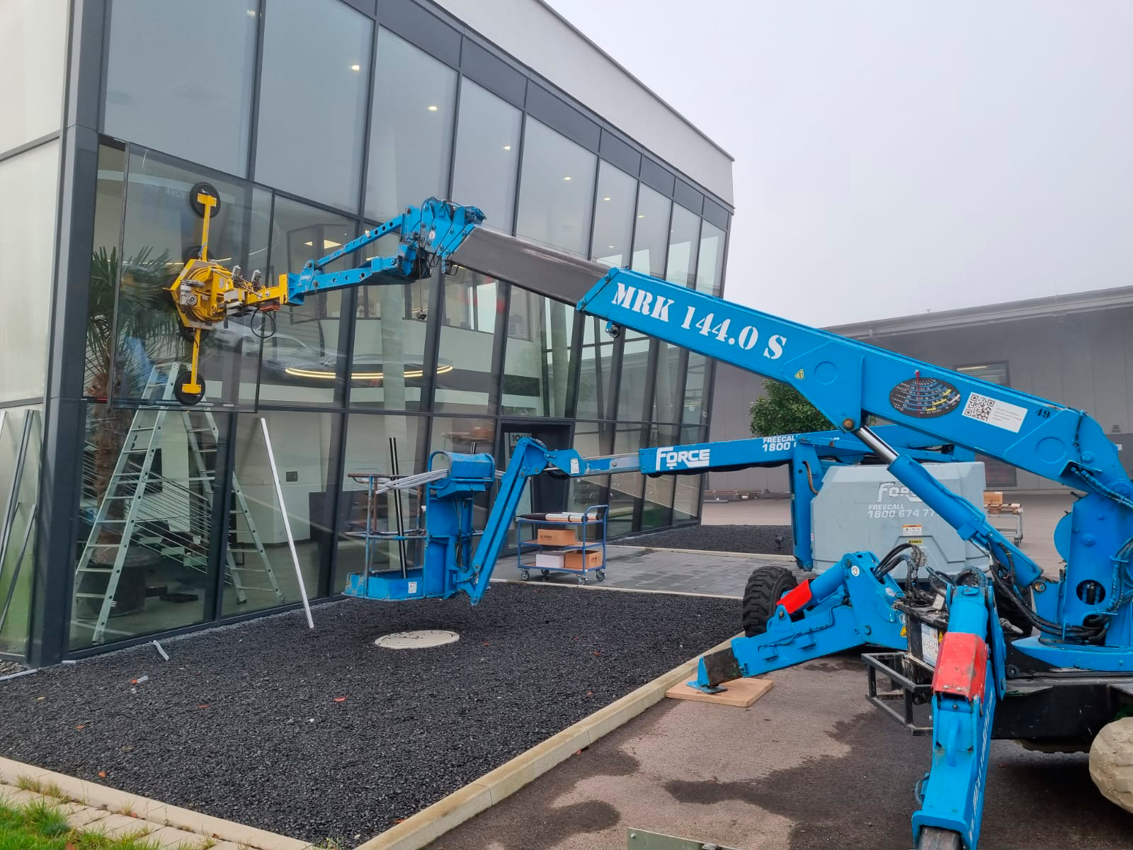 Replacement of a 220 kg (485 lbs) glass pane on sloping façade with Heavydrive MRK 144.0 S crane and 450 K suction system